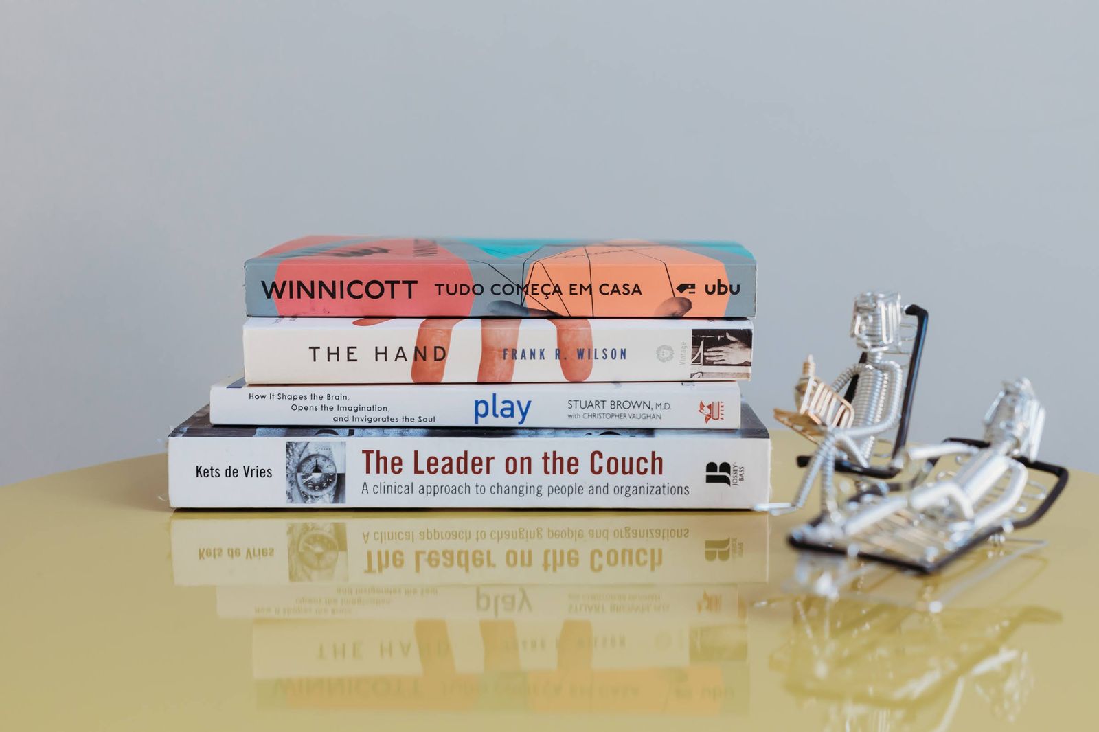 Pilha de livros com The Leader on the Couch, de Kets de Vries, e Winnicott
